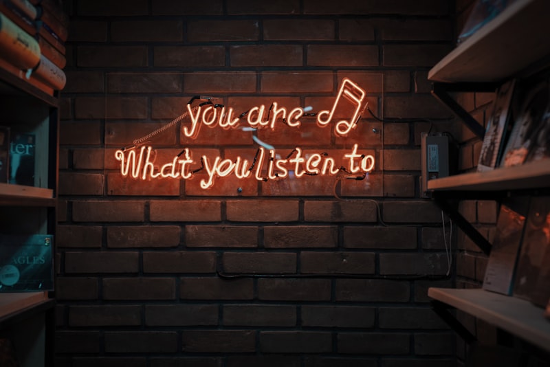 Neon sign about music listening culture on dark wall