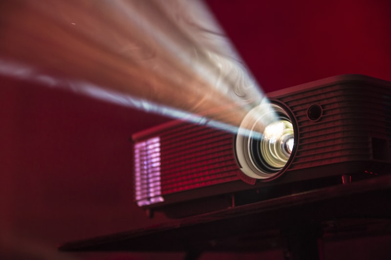 Video projector casting light through cinematic atmosphere