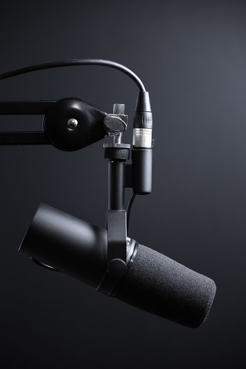 Professional podcast microphone on boom arm against dark background